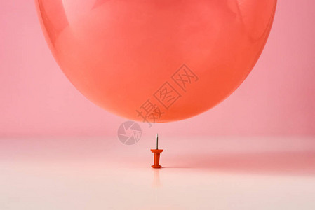 红气球在粉红色背景的针上掉下来危图片