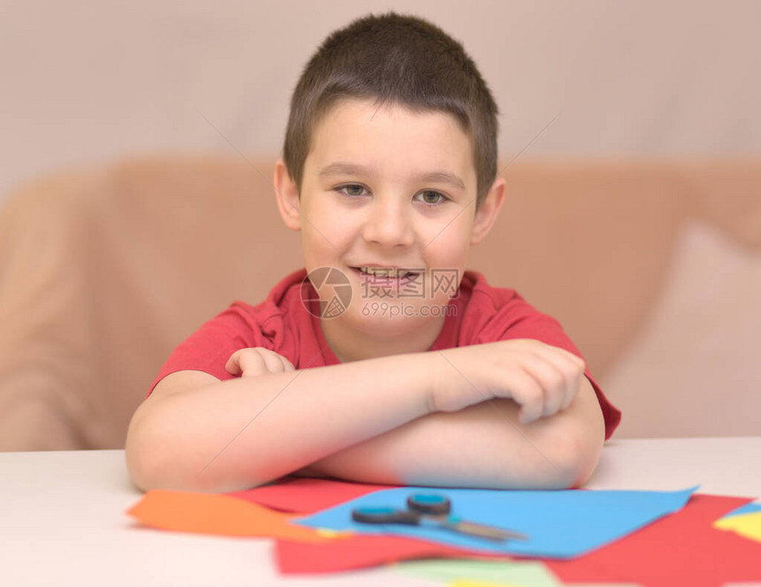 笑得可爱的男孩用剪刀纸教图片