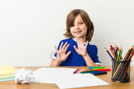 小男孩在桌子上画和做功课拒绝有人表现出厌恶的姿态图片