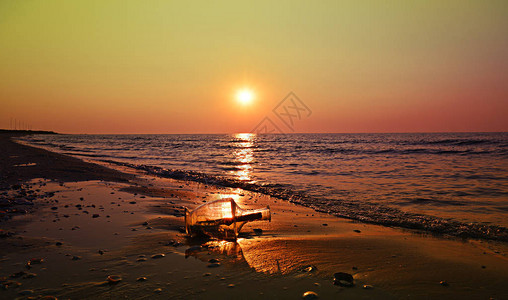 日出时在海滩的瓶子上留言墙壁艺背景图片