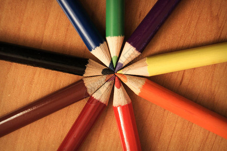 木桌上圆圈中的彩色铅笔图片