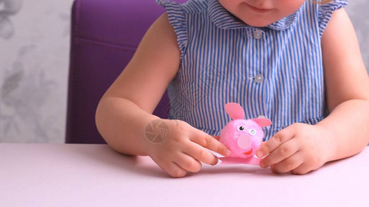 小女孩和母亲一起做一个软玩具粉色猪图片