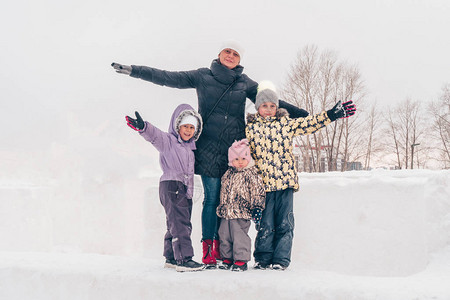 冬天全家福带着三个女儿的妈正在公园里散步家人在户外笑享受图片