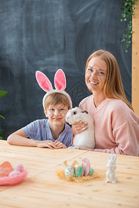 快乐的年轻母亲抱着可爱的兔子图片