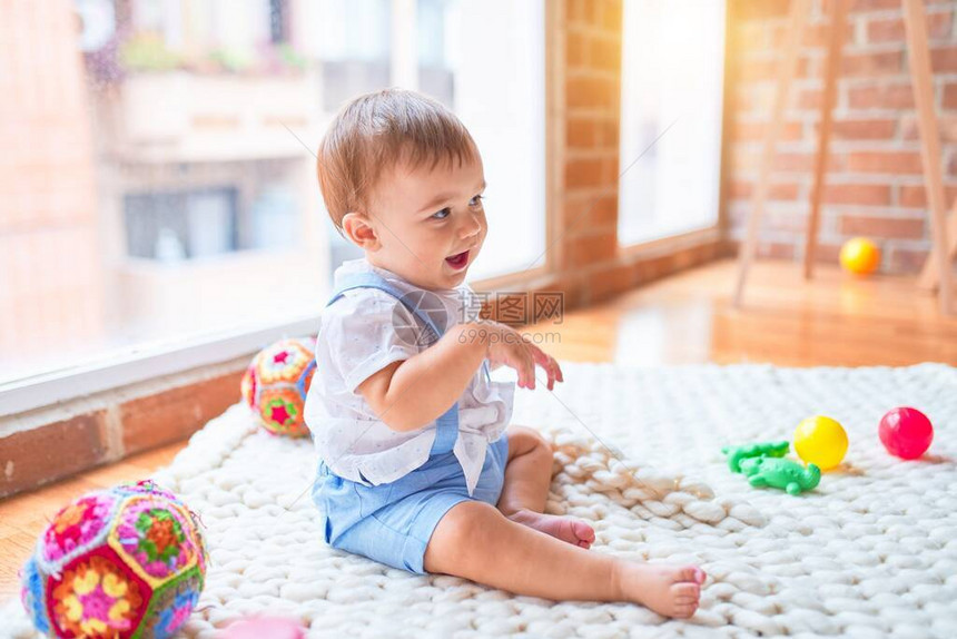 坐在毛毯上坐着的可爱的小孩儿在幼儿园图片