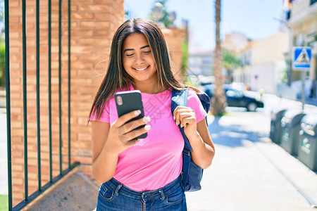 年轻拉丁女学生在大学校园使用智能手机图片