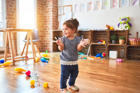 美丽的幼儿们在幼儿园里站在许多玩具图片