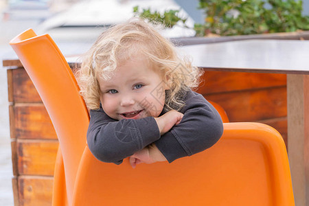 坐在橙色椅子上快乐健康的孩子背景图片