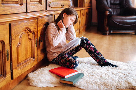 女孩在读一本书在隔离期间在图片