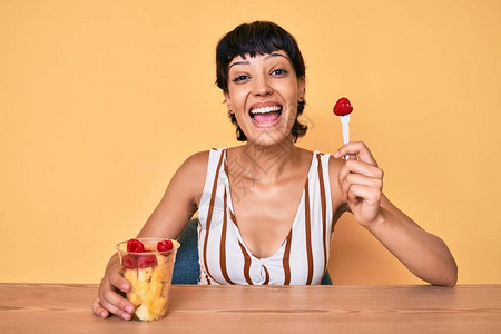 美丽的黑发女人吃新鲜健康的水果图片