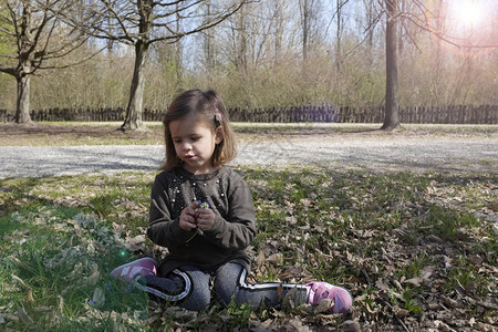 可爱的小女孩45岁坐在公园树下图片