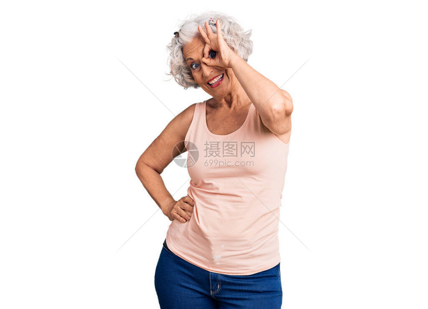 穿着便衣的高级灰色头发妇女笑着快乐地做一个好标记用手在眼睛上图片