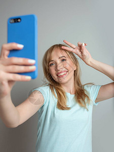 时尚美丽的金发女博主用她的智能手机自拍潮流科技美图片