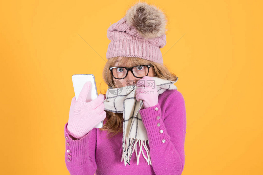 身穿冬季穿搭的女孩用着智能手机图片