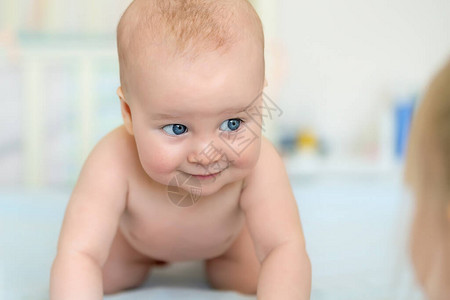 可爱的白种人5个月大的婴儿男婴趴在托儿所的卧室里图片