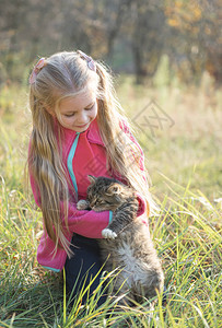孩子抱着小猫小女孩在秋天花园拥抱图片