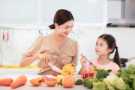 母亲和儿女在吃蔬菜和水果时幸福地享用图片