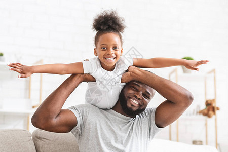 快乐的Afro家庭小女儿和父亲在家玩得开图片