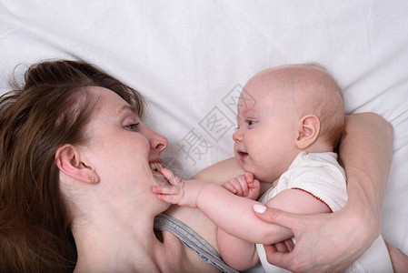美丽的年轻母亲拥抱可爱的婴儿爱着母亲图片