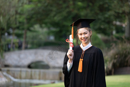 有吸引力的亚洲女学生毕业帽和长袍手拿证书庆祝开学日如此自豪的幸福图片