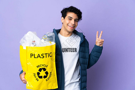 委内瑞拉青年男子拿着一袋装满塑料瓶的塑料瓶微笑并图片