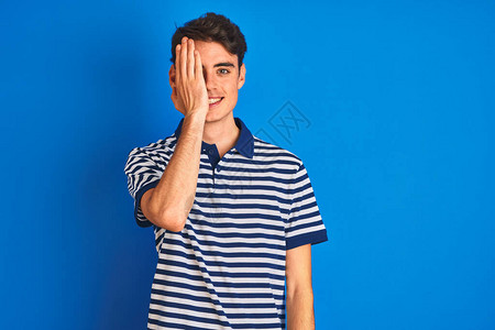 身穿轻便T恤的青少年男孩站在蓝色孤立的背景上图片