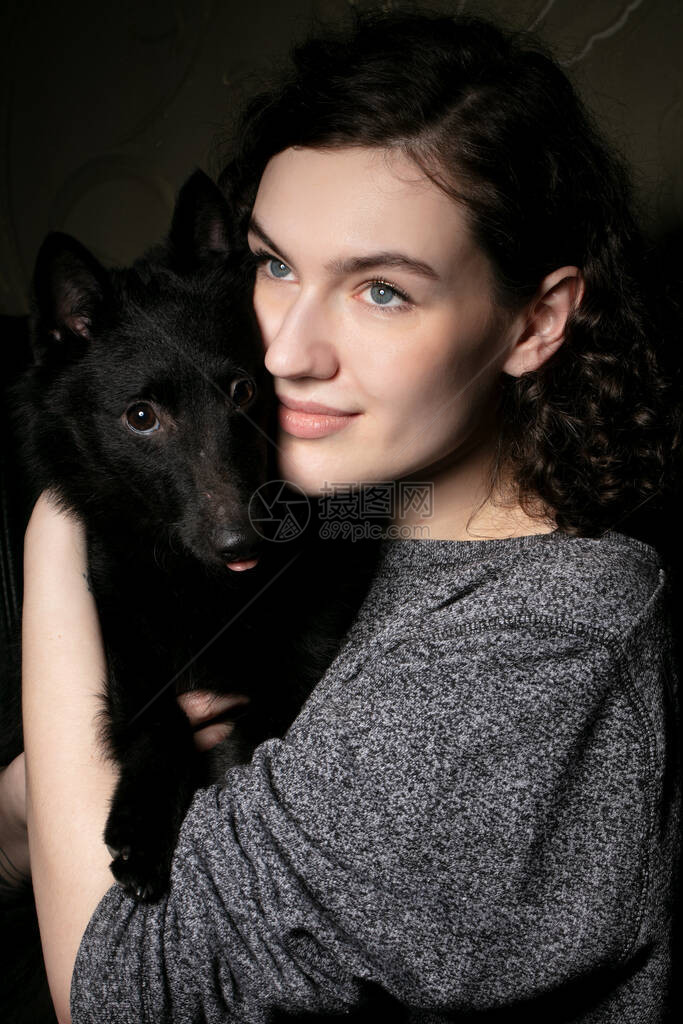 一个带着黑狗的漂亮女孩的肖像带图片
