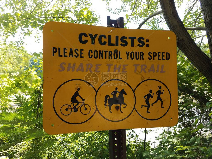 一个黄色骑自行车的人请控制您的速度共享路图片