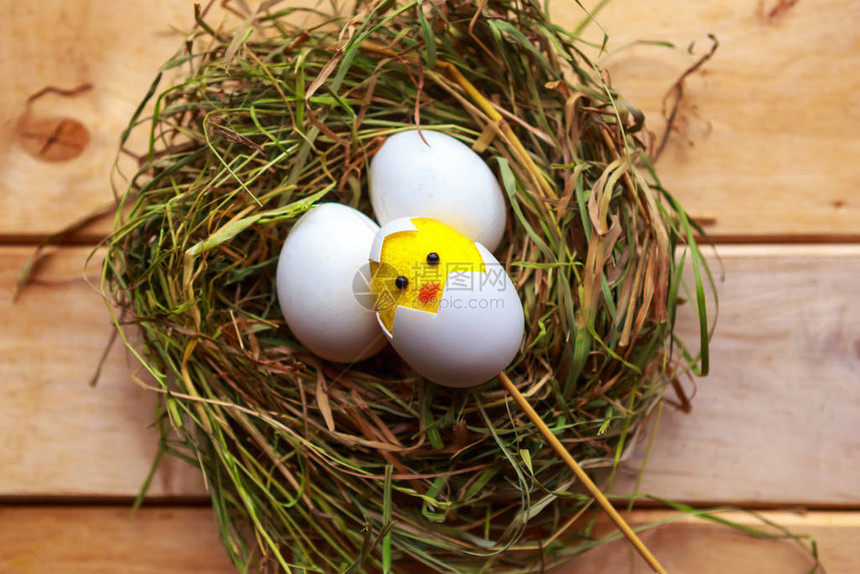 在干草巢中玩具鸡和蛋复活节概念图片