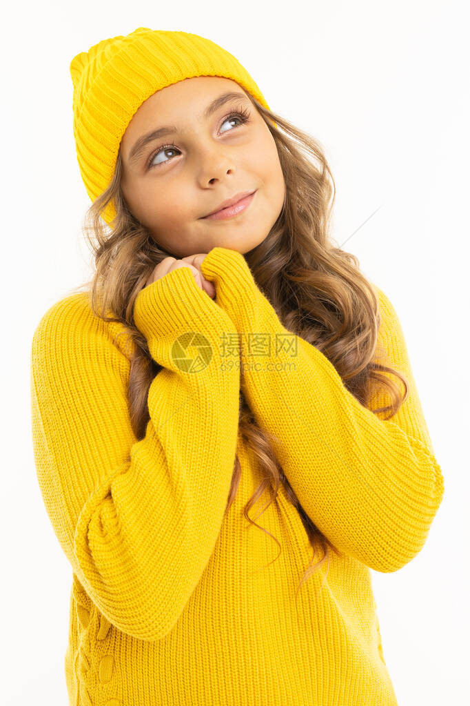 穿着黄色毛衣和帽子的可爱小女孩在白图片