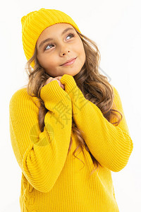 穿着黄色毛衣和帽子的可爱小女孩在白图片