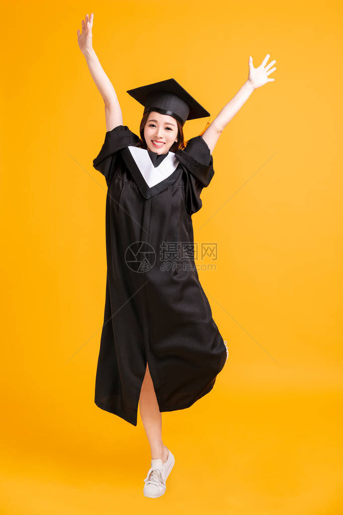 在毕业礼服中快乐的年轻女子图片