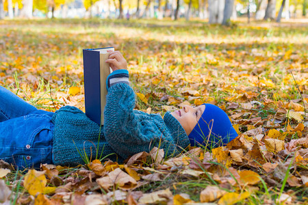 男孩在读一本书在秋图片