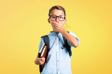 背着包和眼镜的学生男孩用手在黄色图片