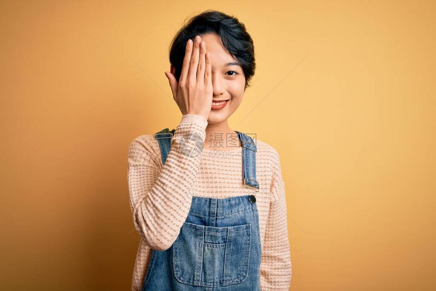 年轻漂亮的亚洲女孩穿着休闲牛仔工作服图片