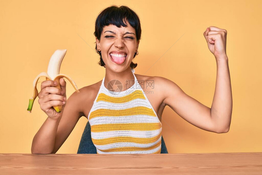 布莱奈特少女吃香蕉作为健康的零食用有趣的表情开心地图片