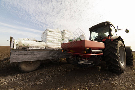 撒播人造肥料的拖拉机运输农业高清图片