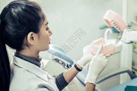 女牙医在诊所向病人解释人工图片