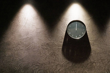 黑色简单的模拟时钟显示午夜挂在深棕色的墙上图片
