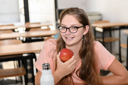 年轻女孩在学校吃苹果图片