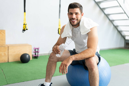 充满自信的拉丁青年男子在健身工作室锻炼图片