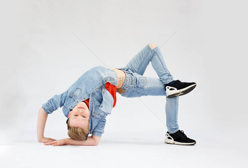 一个年轻男孩在一个独特的破碎舞姿势图片