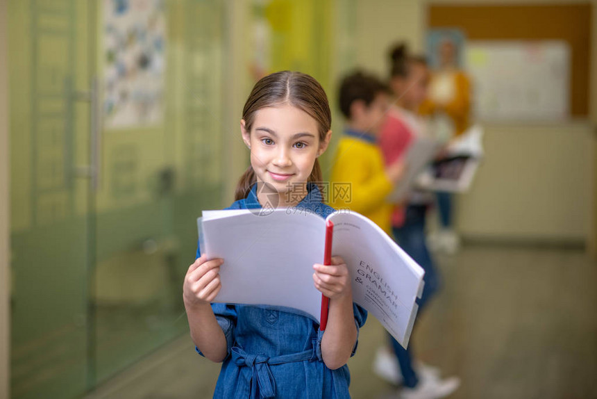 微笑的小女孩站在学校走廊上图片