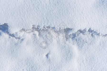 抽象的纹理雪地壳中轻微融化的裂缝图片
