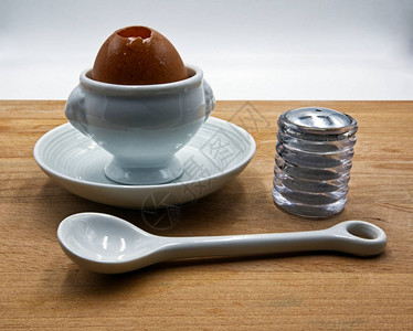 白色陶瓷鸡蛋勺子和盐壶里有的可口鸡蛋木图片