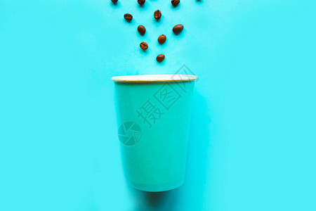 空带走蓝色背景中的咖啡杯和咖啡豆最小的概念图片