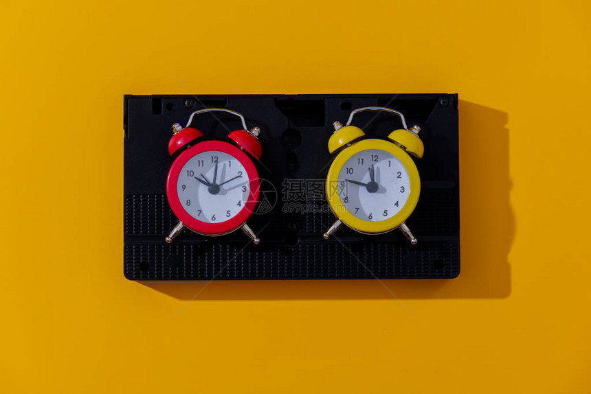 两个古老的闹钟和黄色背景图片