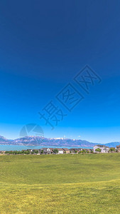 垂直框架湖山住宅和天空的风景与前景中的高尔夫球场图片