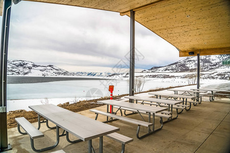 野餐亭俯瞰湖泊和山脉的白雪皑的冬季景观图片