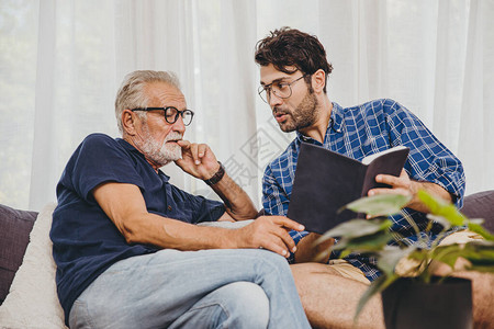 年轻人在家中与退休老人一起咨询商业项目或教科书中的图片